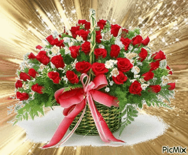 a basket full of red roses and white flowers with a red bow