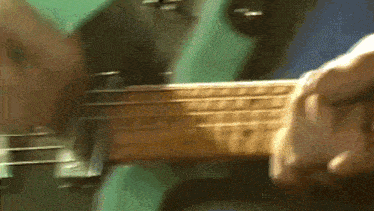 a close up of a person playing a guitar with a blurred background