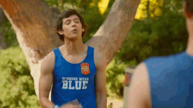 a man wearing a blue tank top with the word blue on it