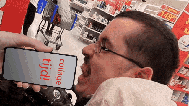a man is holding a cell phone that says collage tiidi on the screen