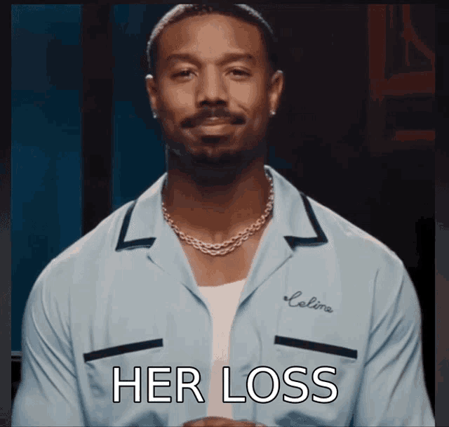 a man wearing a blue shirt that says " her loss " on it