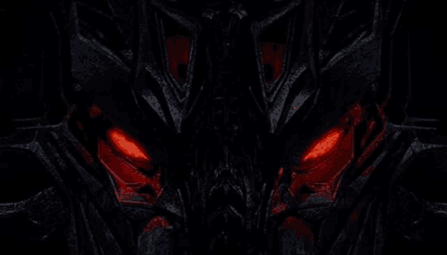 a close up of a transformer with red eyes in the dark .