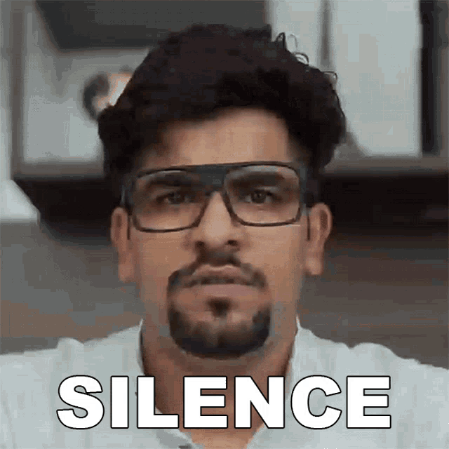 a man with glasses and a beard has the word silence on his face