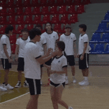 a group of people standing on a basketball court with one wearing a shirt that says ' ucsd '