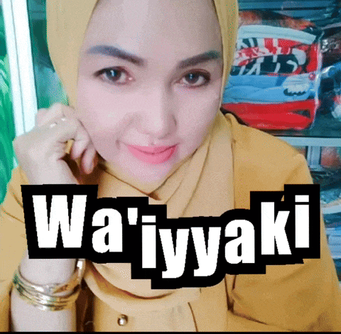 a woman wearing a hijab and a yellow shirt with wa ' iyyaki written on the top