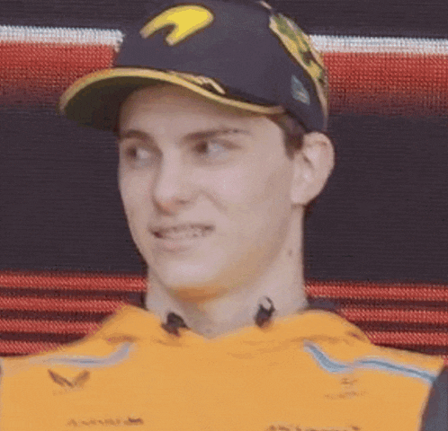 a close up of a man wearing a baseball cap and a yellow shirt .