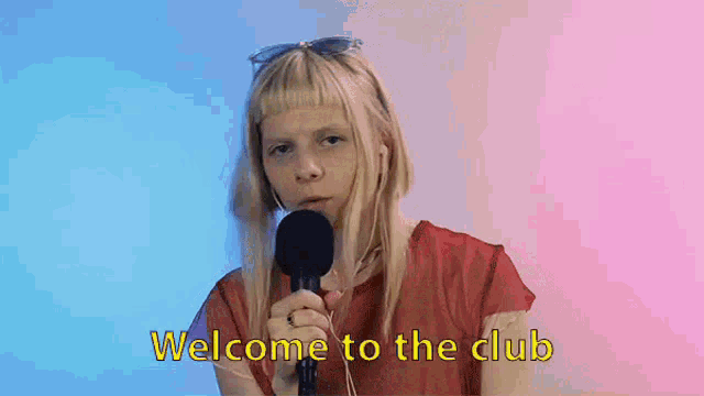 a woman is holding a microphone and talking into it .
