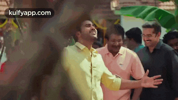 a group of men are standing next to each other in a crowd and one of them is smiling .