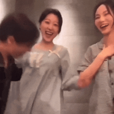 a man and two women are standing next to each other laughing .