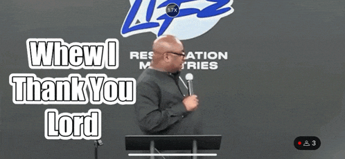 a man stands at a podium with a microphone in front of a sign that says " whew ! thank you lord "