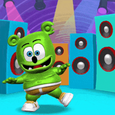 a gummy bear is dancing on a stage with speakers in the background