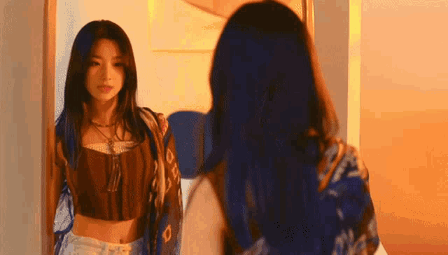 a woman is looking at herself in a mirror