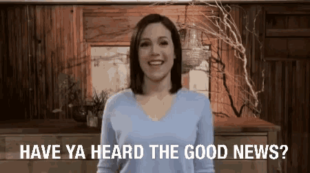 a woman in a blue sweater is smiling and says have ya heard the good news