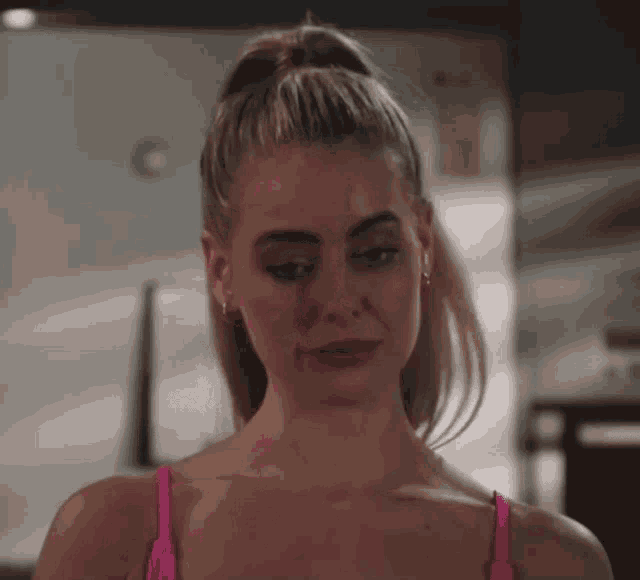 a woman in a pink tank top is looking at something