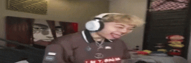 a young man wearing headphones is making a funny face in a room .