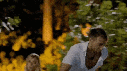 a man and a woman are running through a forest .