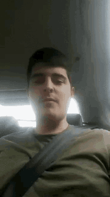 a man is wearing a seat belt while sitting in a car