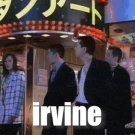 a group of people standing in front of a sign that says " irvine "