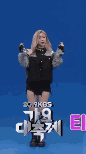 a woman is dancing in front of a blue background with 2019 kbs written on it