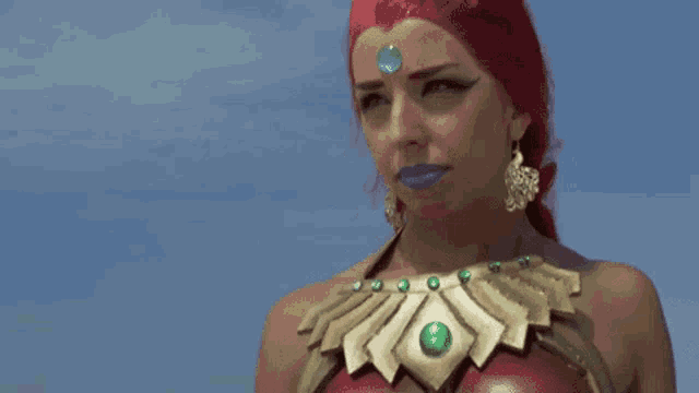 a woman with red hair is wearing a necklace with green beads