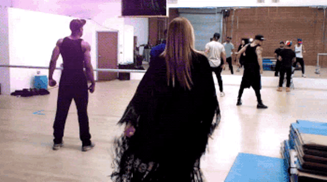 a man and a woman are dancing in a gym