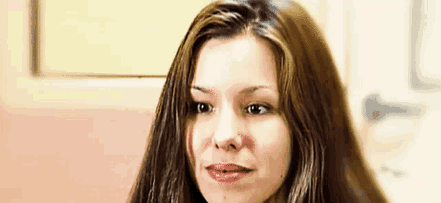 a close up of a woman 's face with long hair and a pink lip .