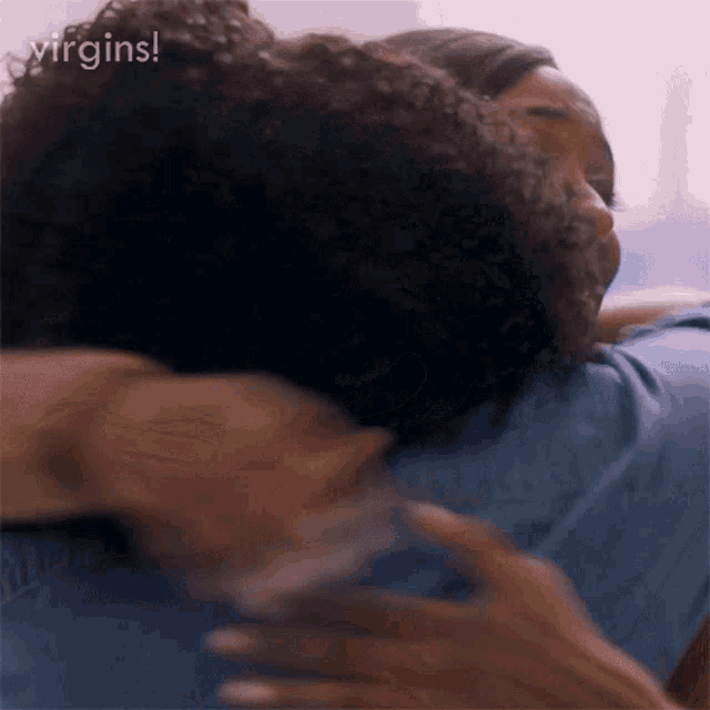 a man and a woman are hugging each other and the woman is holding the man 's arm .