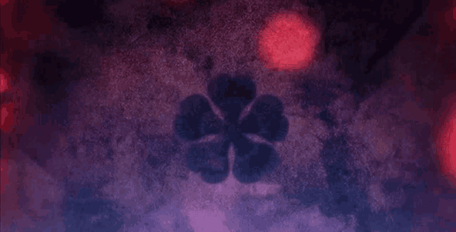 a purple background with a black clover on it .