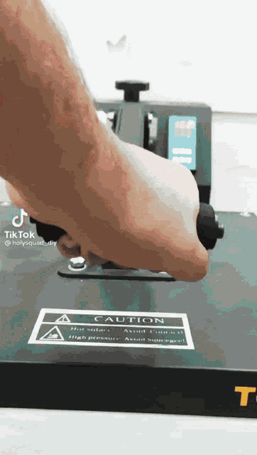 a person is using a machine that has a caution sign on it .