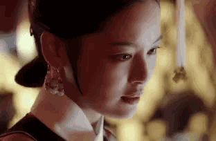 a close up of a woman 's face wearing a traditional costume and earrings .