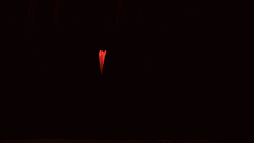 a woman sings into a microphone on a stage with a red curtain behind her