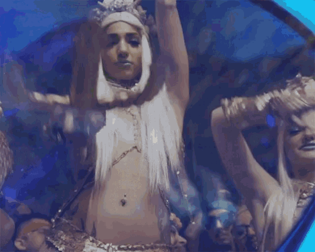 a woman with white hair is dancing in front of a crowd of people