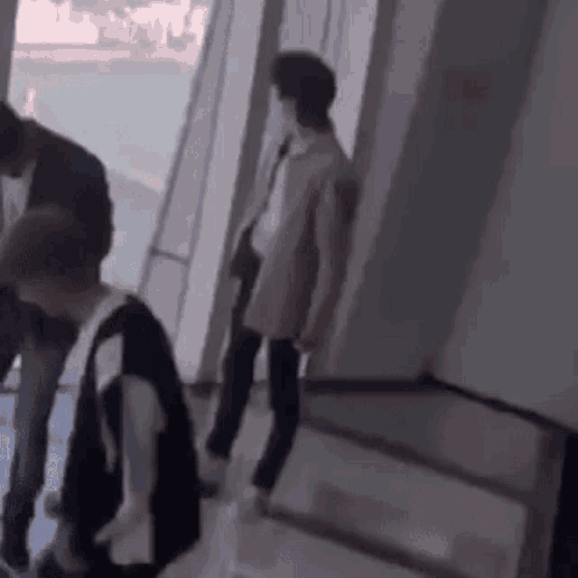 a group of people are standing in a hallway and talking to each other .