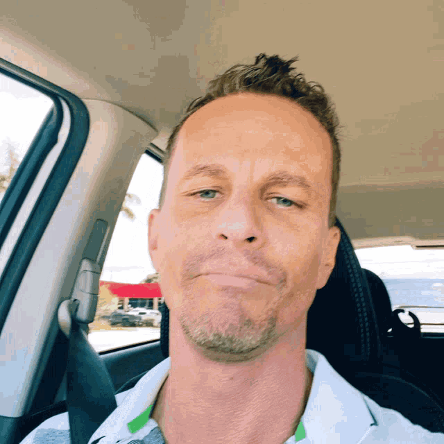 a man with a beard is sitting in the back seat of a car