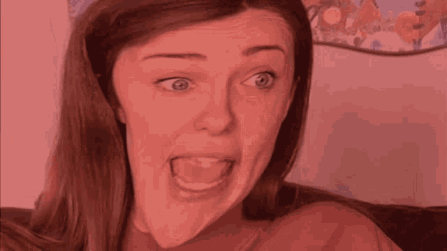 a woman is making a funny face while sitting on a brown couch
