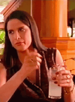 a woman sitting at a table with a glass of water in her hand