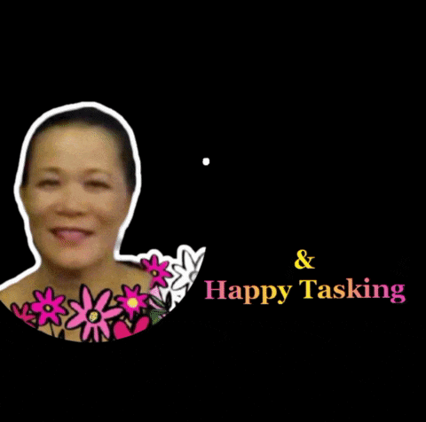 a woman is smiling in front of a sign that says " welcome & happy tasking "