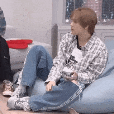a man is sitting on a bean bag chair holding a video game controller .