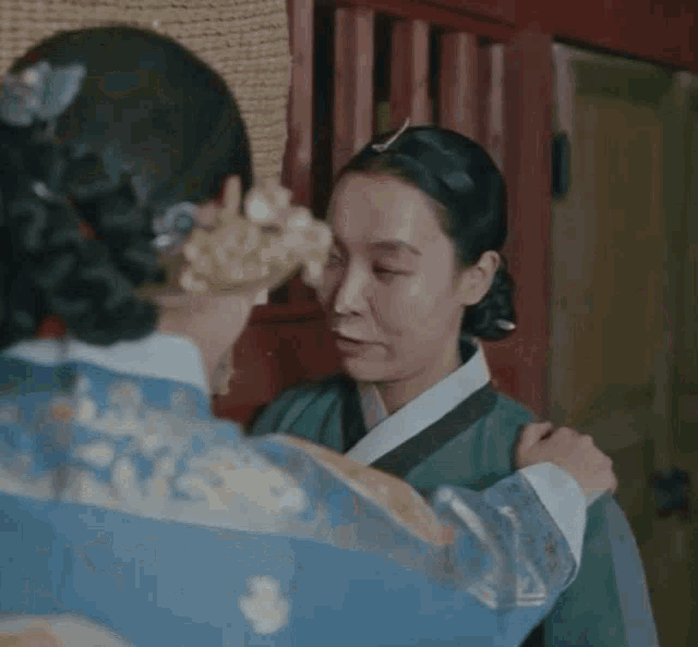 a woman in a blue and gold costume is looking at another woman in a blue and gold costume .