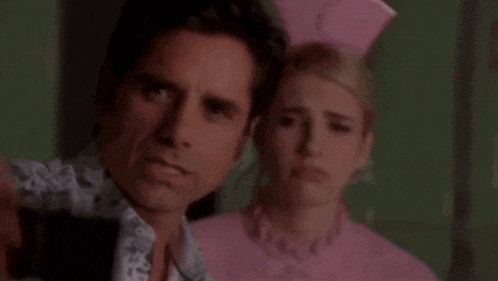 a man and a woman are standing next to each other in a room .