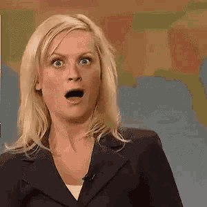 a woman with a surprised look on her face is holding a sign that says esquiseme .