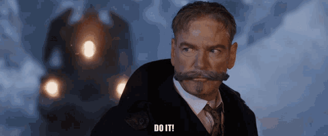 a man with a beard and mustache says do it in front of a train
