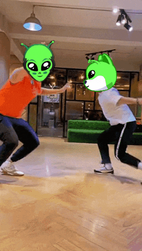 a man with a green alien head is dancing with another man with a green dog head
