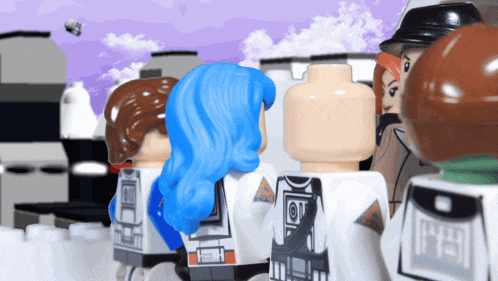 a group of lego figures are standing in a line and one of them has a blue hair