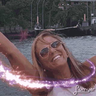 a woman wearing sunglasses is smiling with her arms outstretched