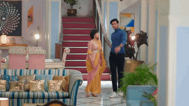 a man and woman are standing in a living room holding hands