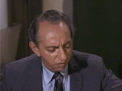 a man in a suit and tie sits at a table