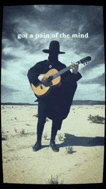 a man playing a guitar in the desert with the words got a pain of the mind
