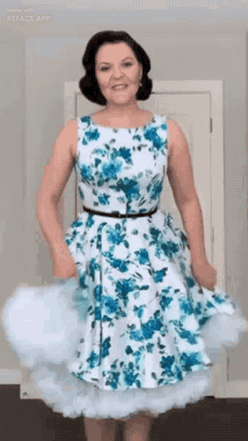 a woman wearing a blue and white floral dress
