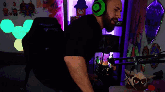 a man wearing green headphones is standing in front of a microphone